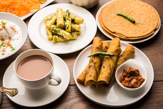 Groep Gujarati-snacks zoals jalebi-fafda, thepla, khaman dhokla, aloo bhujiya, khandvi, khakra, dahi vada, gathiya met hete thee