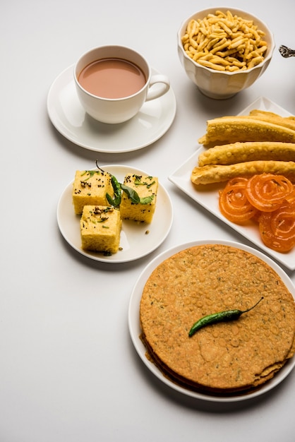 Groep Gujarati-snacks zoals jalebi-fafda, thepla, khaman dhokla, aloo bhujiya, khandvi, khakra, dahi vada, gathiya met hete thee