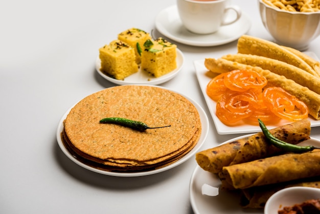 Groep Gujarati-snacks zoals jalebi-fafda, thepla, khaman dhokla, aloo bhujiya, khandvi, khakra, dahi vada, gathiya met hete thee