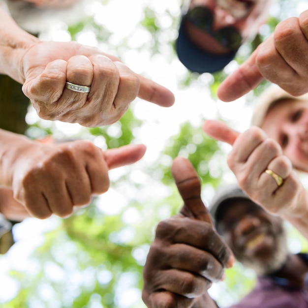 Groep hogere vrienden in openlucht beduimelt omhoog positiviteitsconcept