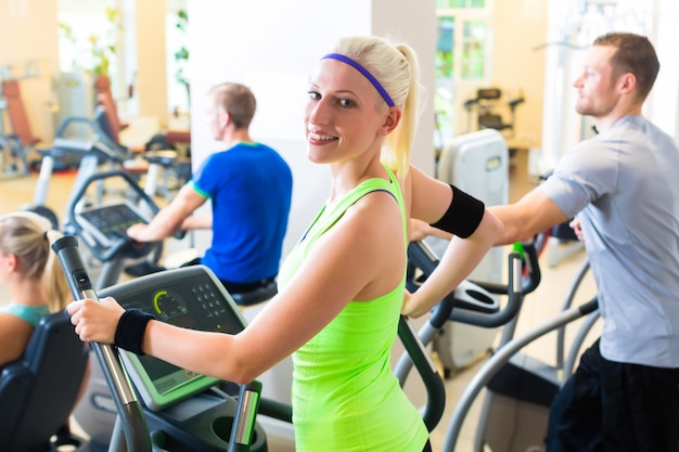 Groep in gymnastiek op elliptische trainer