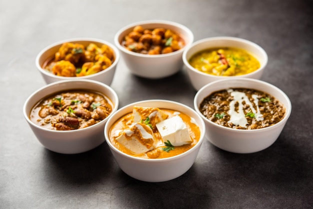 Groep indiase vegetarische gerechten, hete en pittige punjabi-keukenmaaltijdassortiment in kommen
