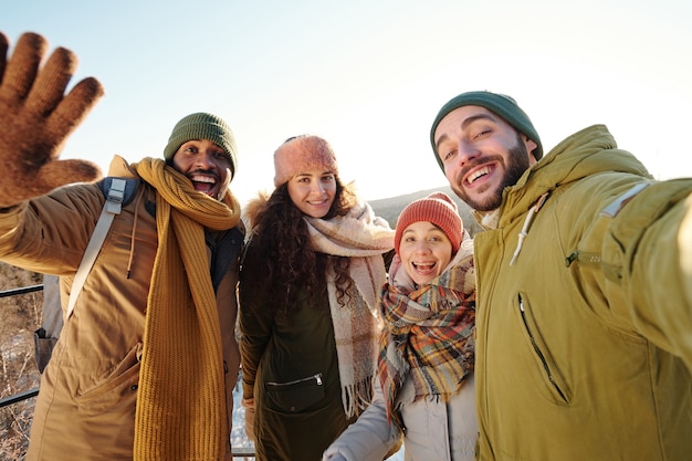 Groep interculturele vrienden die selfie maken tijdens chill op winterdag