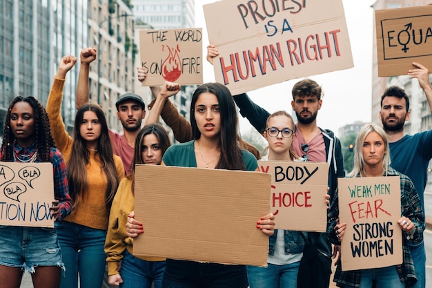 Groep jonge activisten die panelen houden die protesteren voor gelijkheid, geslacht en klimaatverandering meisje met spandoek met kopieerruimte