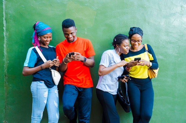 Groep jonge Afrikaanse studenten die enthousiast zijn over de zaag op hun mobiel