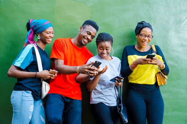 Groep jonge Afrikaanse studenten die enthousiast zijn over de zaag op hun mobiel