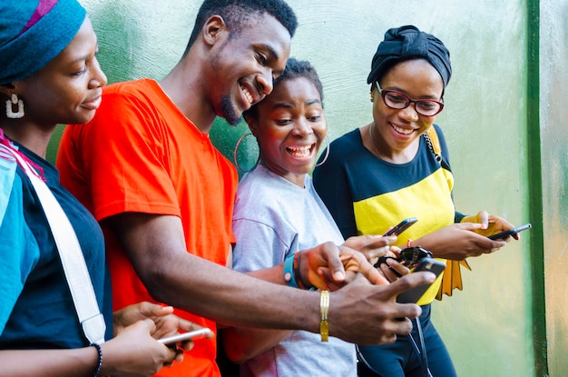 Groep jonge Afrikaanse studenten die enthousiast zijn over de zaag op hun mobiel