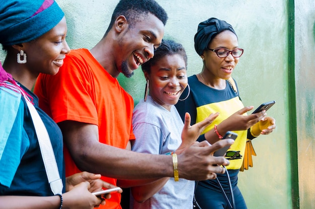 Groep jonge Afrikaanse studenten die enthousiast zijn over de zaag op hun mobiel