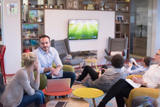 Groep jonge bedrijfsmensen die businessplan bespreken bij de moderne startbureaubouw