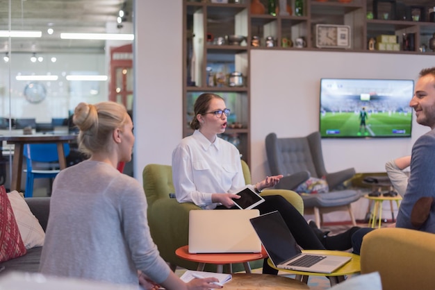 Groep jonge bedrijfsmensen die businessplan bespreken bij de moderne startbureaubouw