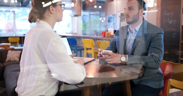 Groep jonge bedrijfsmensen die businessplan bespreken bij de moderne startbureaubouw