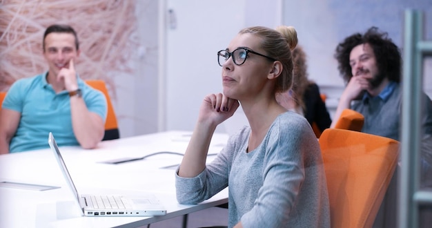 Groep jonge bedrijfsmensen die businessplan bespreken bij de moderne startbureaubouw