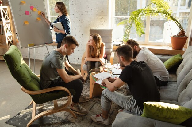 Foto groep jonge blanke kantoormedewerkers die bijeenkomen om nieuwe ideeën te bespreken creatieve bijeenkomst