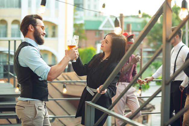 Groep jonge blanke mensen vieren, zien er gelukkig uit, hebben een bedrijfsfeest op kantoor of in de bar