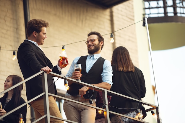 Groep jonge blanke mensen vieren, zien er gelukkig uit, hebben een bedrijfsfeest op kantoor of in de bar