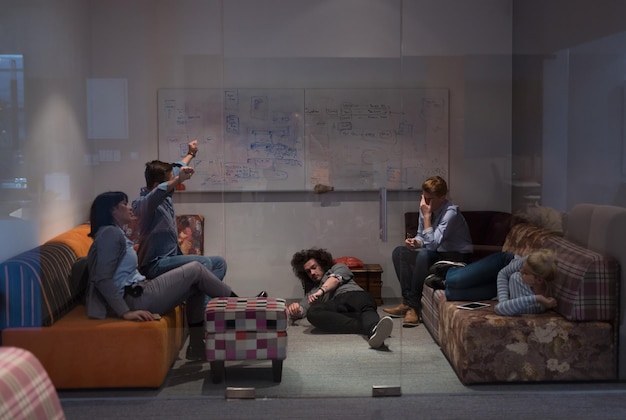 groep jonge casual softwareontwikkelaars die op de bank slapen tijdens een werkpauze in een creatief opstartkantoor