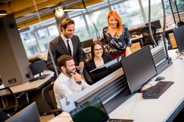 Groep jonge mensen uit het bedrijfsleven werken samen met desktop computer