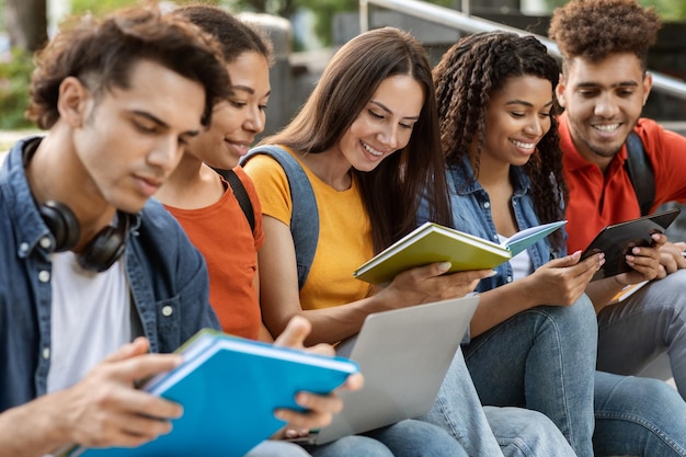 Groep jonge multi-etnische mensen studeren samen buiten