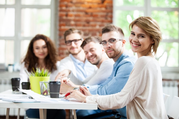 Groep jonge multiraciale mensen die werken in een modern licht kantoor. Zakenlieden aan het werk tijdens de vergadering.