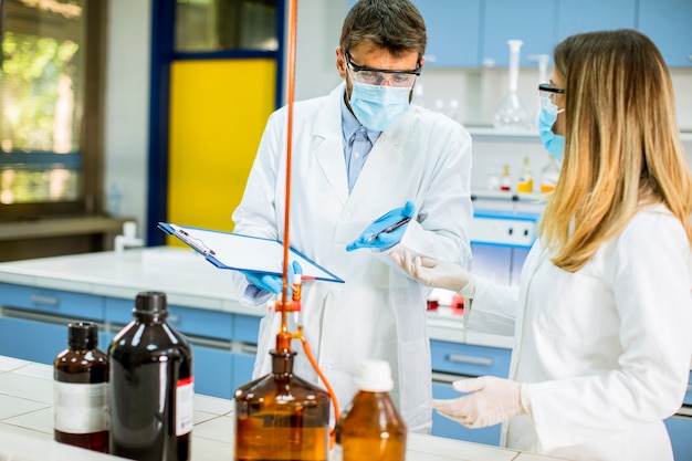 Groep jonge onderzoekers die chemische gegevens in het laboratorium analyseren