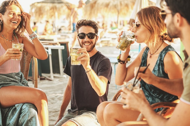 Groep jonge vrienden met een feestje in de strandbar.