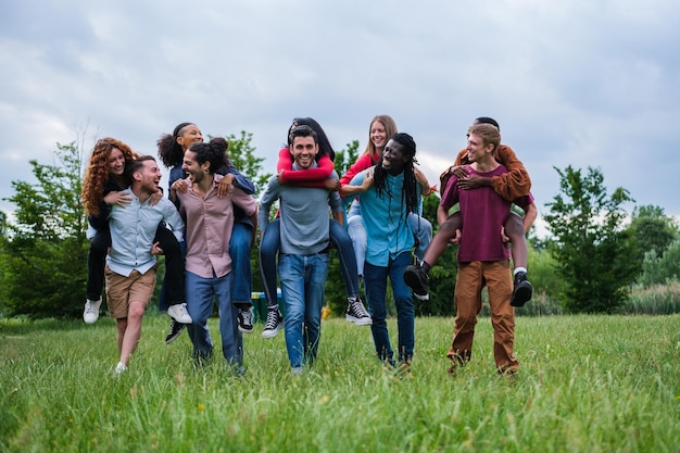 Groep jonge vrienden uit verschillende culturen die buiten in het park spelen en plezier hebben