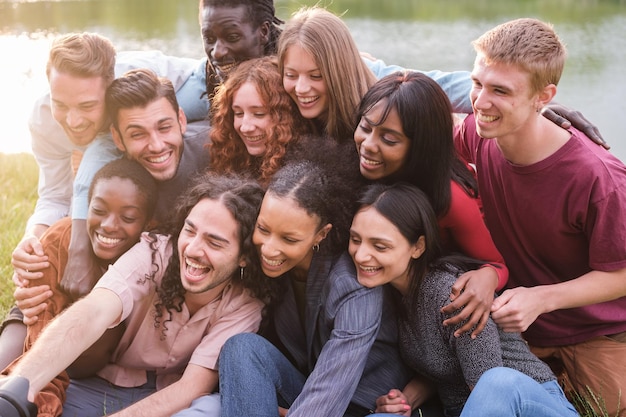 Groep jonge vrienden van verschillende afkomst die samen een selfie maken buiten in het park Concept diversiteit trots vriendschap