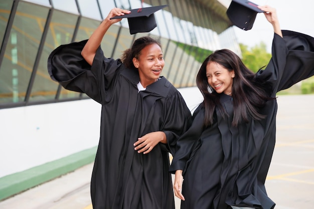 Groep jonge vrouwelijke student die toga draagt en een diploma behaalt Gelukkig afgestudeerd succes en feest Gefeliciteerd