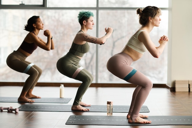 Groep jonge vrouwen trainen met rubberen band tijdens sporttraining in de sportschool