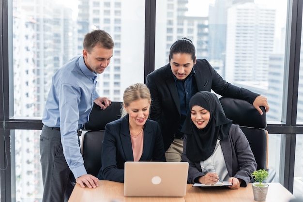 Groep jonge zakenmensen die aan het bureau werken en communiceren