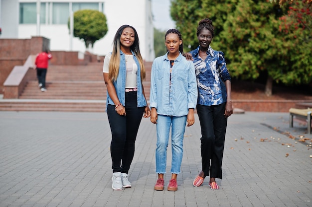 Groep jonge zwarte vrouwelijke vrienden die rondhangen in de stad multiraciale afrikaanse vrouwen die door de straat lopen en discussiëren