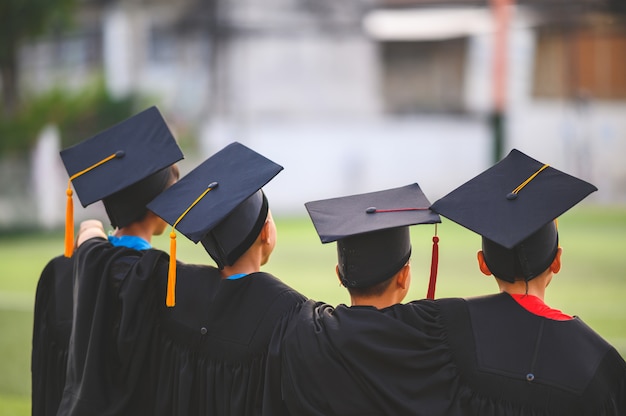 Groep jongens zijn blij op hun afstuderen dag op school