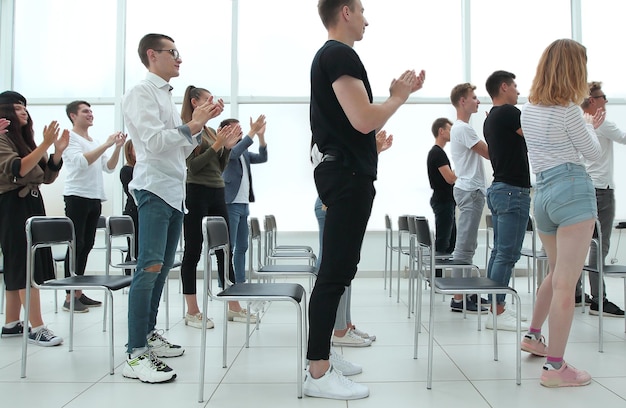 Groep jongeren die applaudisseren in de vergaderruimte