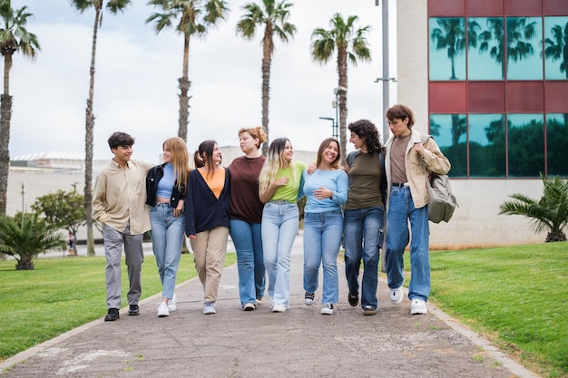 Groep jongeren die door de universiteitstuinen lopen terwijl ze een pauze nemen van het studeren