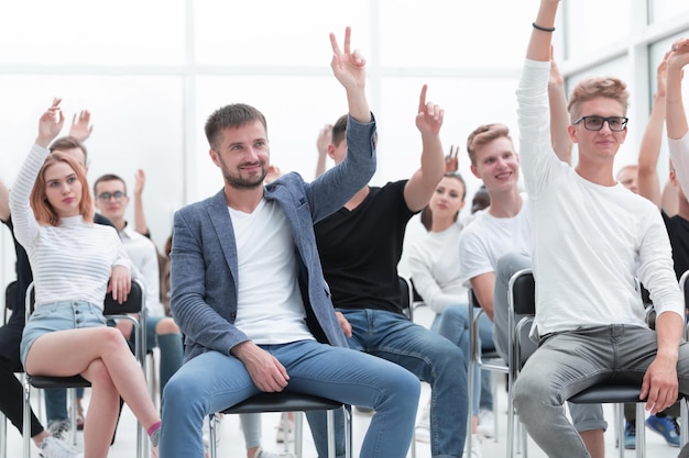 Groep jongeren die hun hand opsteken om een vraag te stellen