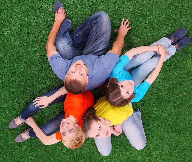 Groep jongeren die op groen gras zitten