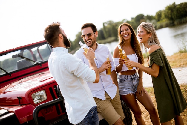 Groep jongeren drinken en plezier met de auto buiten