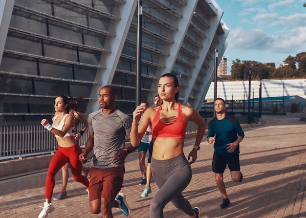 Groep jongeren in sportkleding die samen buiten joggen