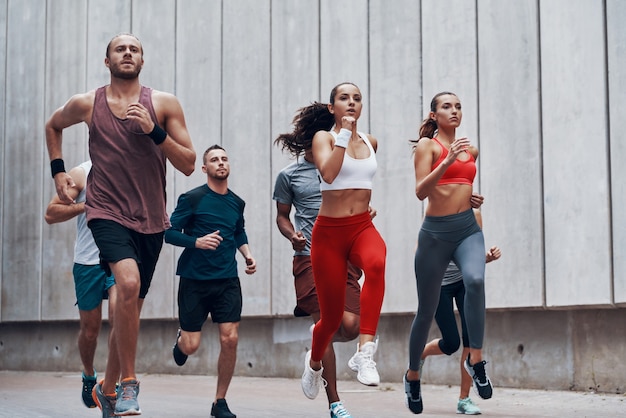 Groep jongeren in sportkleding joggen tijdens het sporten buitenshuis