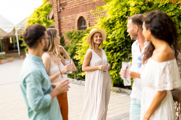 Groep jongeren juichen en plezier buiten met drankjes