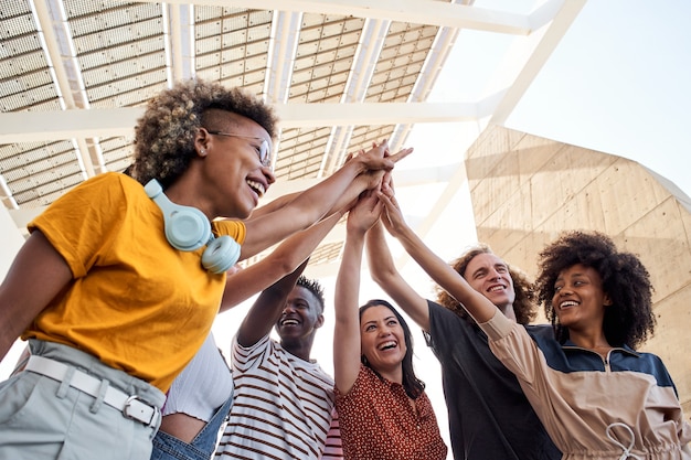 Groep jongeren stapelen hand multi-etnische groep studenten buiten vieren