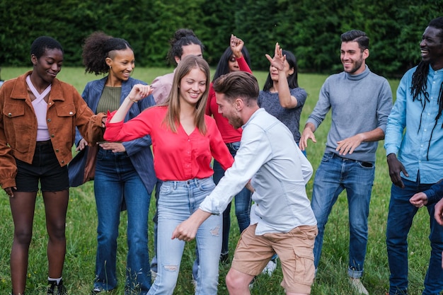 Groep jongeren van verschillende nationaliteiten die dansen en samen plezier hebben in de buitenlucht