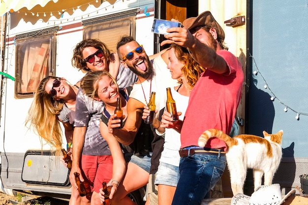 Groep jongeren vrienden nemen selfie foto in platteland vakantie levensstijl en oude caravan camper