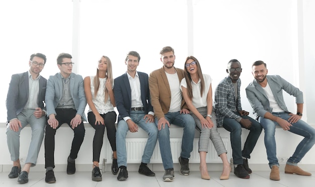 Groep jongeren wacht op een interview zittend in de kantoorlobbyphoto met kopieerruimte