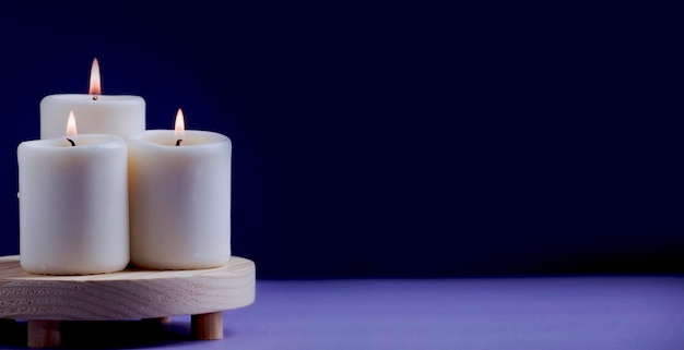 Groep kaarsen met vlam op hout en violette ruimte als achtergrond voor tekst