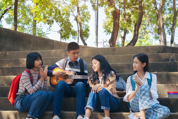 Groep kind student gitaar spelen en liedjes samen zingen in zomer park