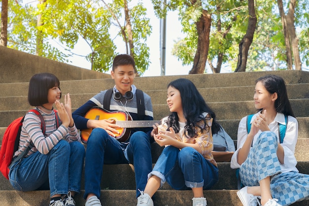 Groep kind student gitaar spelen en liedjes samen zingen in zomer park