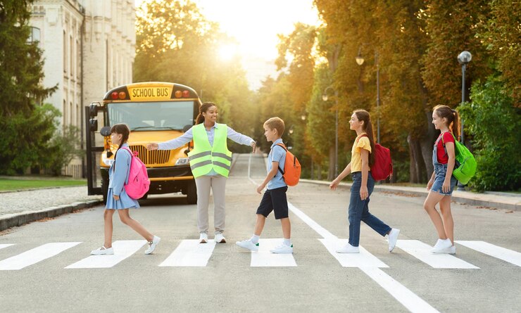 Groep kinderen passeren zebrapad op weg naar schoolbus