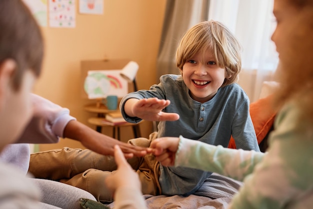 Foto groep kinderen spelen steen papier schaar op bed in cirkel