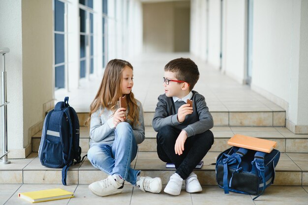 Groep klasgenoten aan het lunchen tijdens de pauze met focus op lachend meisje met appel